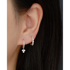 Close-up of S925 sterling silver hoop earrings with zircon stones on a model's ear