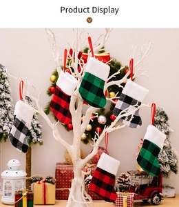 Plaid Christmas stockings hanging on white branches for festive holiday decoration