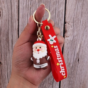 Close-up of PVC Santa Claus doll keychain with red rubber strap and golden ring