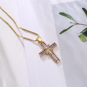 Close-up of golden box chain with a cross pendant featuring a purple rectangular zircon