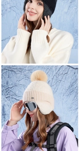 Detail view of winter ear-protection knit hats with plush pom-poms and warm fleece lining