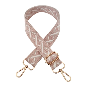 Detail of pink and white diamond jacquard bag strap with polished gold hardware