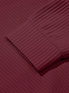 Macro detail of wine red ribbed knit fabric and sleeve stitching on men's pullover