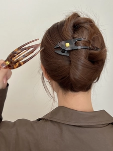 Detail of durable PC resin hair clips with golden fashion buckles in amber and black
