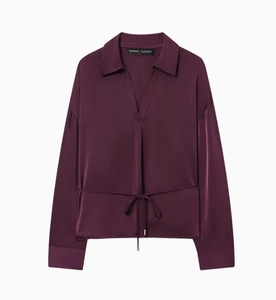 Dettaglio della camicia in raso viola con scollo a V e coulisse regolabile in vita