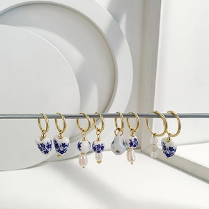 Macro detail of Chinese style enamel heart and porcelain drop earrings with pearls