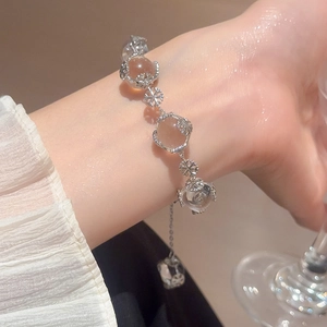Close-up of crystal beaded snowflake bracelet on wrist with warm indoor lighting