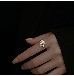 Detailed close-up of golden spinning windmill ring with pavé cubic zirconia stars