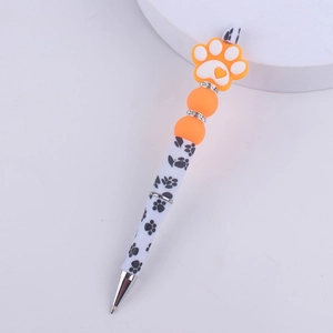 Detail of DIY beaded pen with orange dog paw silicone bead and heart pattern print