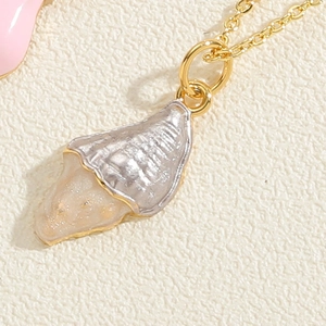 Detailed macro view of the gold seashell pendant with glistening resin and fine textures