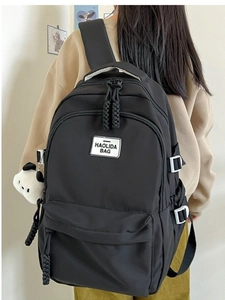 Minimalist black nylon backpack for students featuring a spacious design and brand label