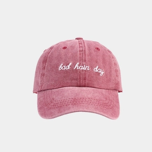 Detail of bad hair day embroidery on washed pink cotton vintage baseball cap