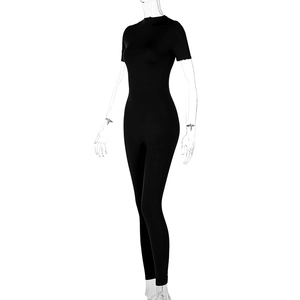 Close-up of black tight-fitting yoga jumpsuit with short sleeves and front zipper detail