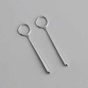 Macro shot of silver metal hoop earrings with elegant vertical bar pendants