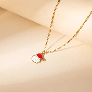 Detailed close-up of golden Santa Claus enamel pendant necklace on minimalist background