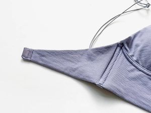Macro detail of lavender ribbed cotton fabric and delicate thin straps on a backless bra