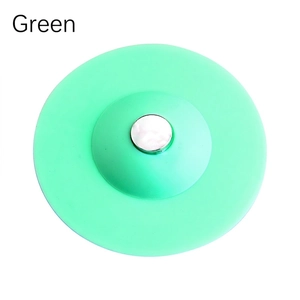 Green silicone sink stopper with a silver push button for kitchen and bathroom drains