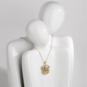 Detail showing colorful zircon devil eye palm pendant with tassel on white mannequins