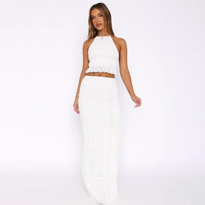 Detail of white two-piece set featuring ruffled halter top and layered maxi skirt texture