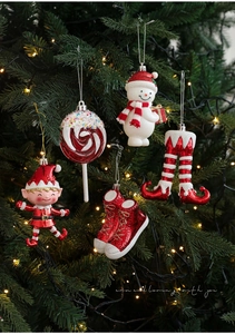 Detail of red and white glittery Christmas ornaments hanging on a green festive tree