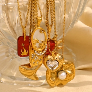 Close-up of 18K gold plated heart and whale tail pendants with red agate and pearls