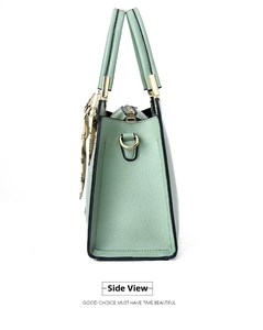 Side view of mint green leather handbag with lychee texture and gold hardware detailing