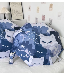 Detail of cute blue cartoon cat patterns on folding umbrella with matching portable storage pouch