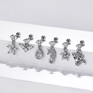 Polished steel cartilage studs with zircon fox and seahorse charms on white steps