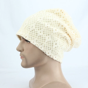 Close-up of beige hollow crochet knit beanie showing breathable lace texture and wavy edges