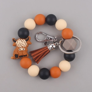 Close-up of highland cow bead bracelet with brown tassel and metal keyring