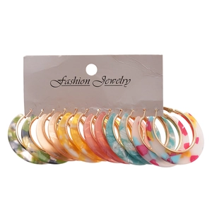 Colorful C-shaped acetate hoop earrings with leopard and marble patterns on display card