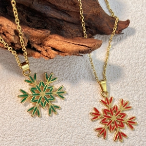 Collana con ciondolo a fiocco di neve dorato con dettagli in smalto rosso e verde