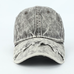 Detailed close-up of distressed denim baseball cap showing frayed edges and vintage texture