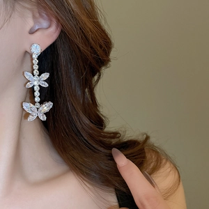 Detail of silver butterfly tassel earrings with sparkling cubic zirconia on model