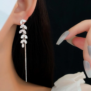 Detail of silver leaf earrings with cubic zirconia worn by model for elegant style
