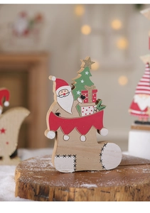 Detail of wooden Christmas table decor featuring Santa and tree in a warm festive setting