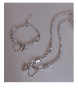 Detail of silver heart jewelry set featuring textured mixed chains and 3D pendants