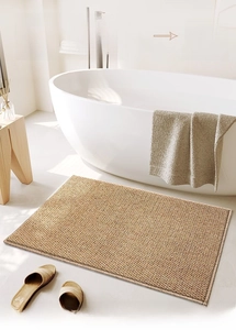 Detail of beige sisal-style bathroom mat with woven texture and anti-slip backing