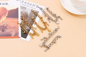 Detail of double-layer bead bracelets with key and lock charms in gold and silver
