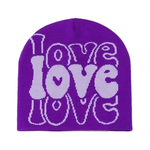 Close-up of knit LOVE letter jacquard pattern on a purple winter beanie hat
