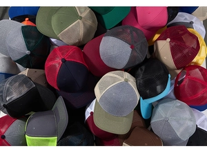 A vibrant stack of mesh trucker hats in red, green, gray, and blue breathable fabric