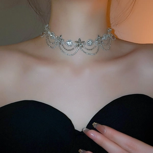 Close-up of sparkling flower and star rhinestones with layered fringe tassel on silver choker