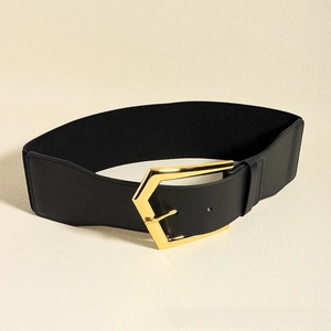 Detail of a wide elastic belt with premium black leather and large gold geometric buckle