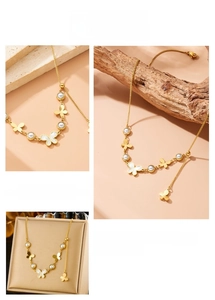 Detail of gold butterfly necklace with pearls on a beige jewelry box backdrop