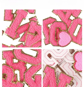Detailed view of rose pink and white chenille letter patches with gold glitter edges