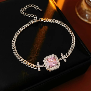 Detail of silver Cuban chain bracelet featuring a pink square zircon and star elements