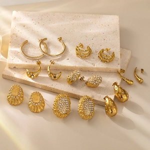 Elegant gold-plated C-hoop earrings with sparkling zircon stones on natural stone pedestals