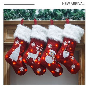 Detail of light-up Christmas stockings with LED lights and white snowflake embroidery