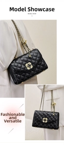 Detail of adjustable metal chain strap with gold clover clasp on black quilted leather bag