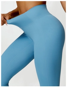 Detail showing high-elasticity wide waistband on light blue high-waist yoga pants